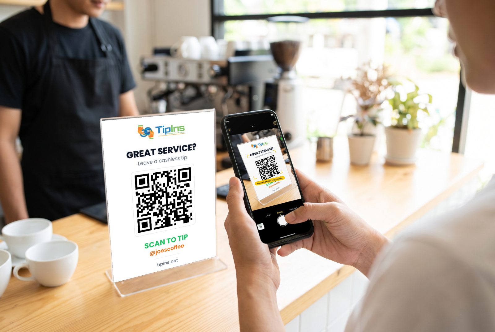 A customer scanning a TipIns QR sign on a café counter with their phone camera
