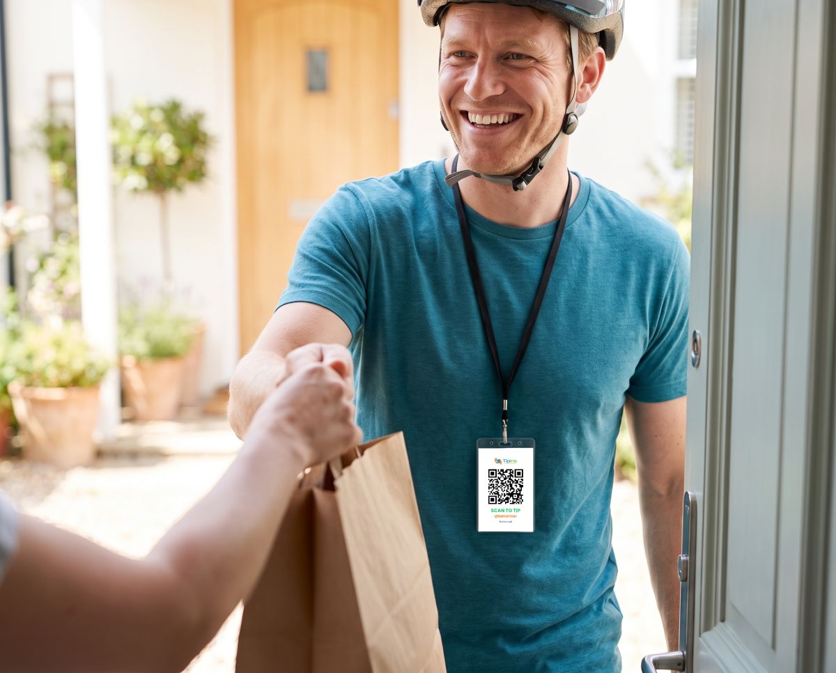 Tom handing over a food delivery wearing a TipIns QR card