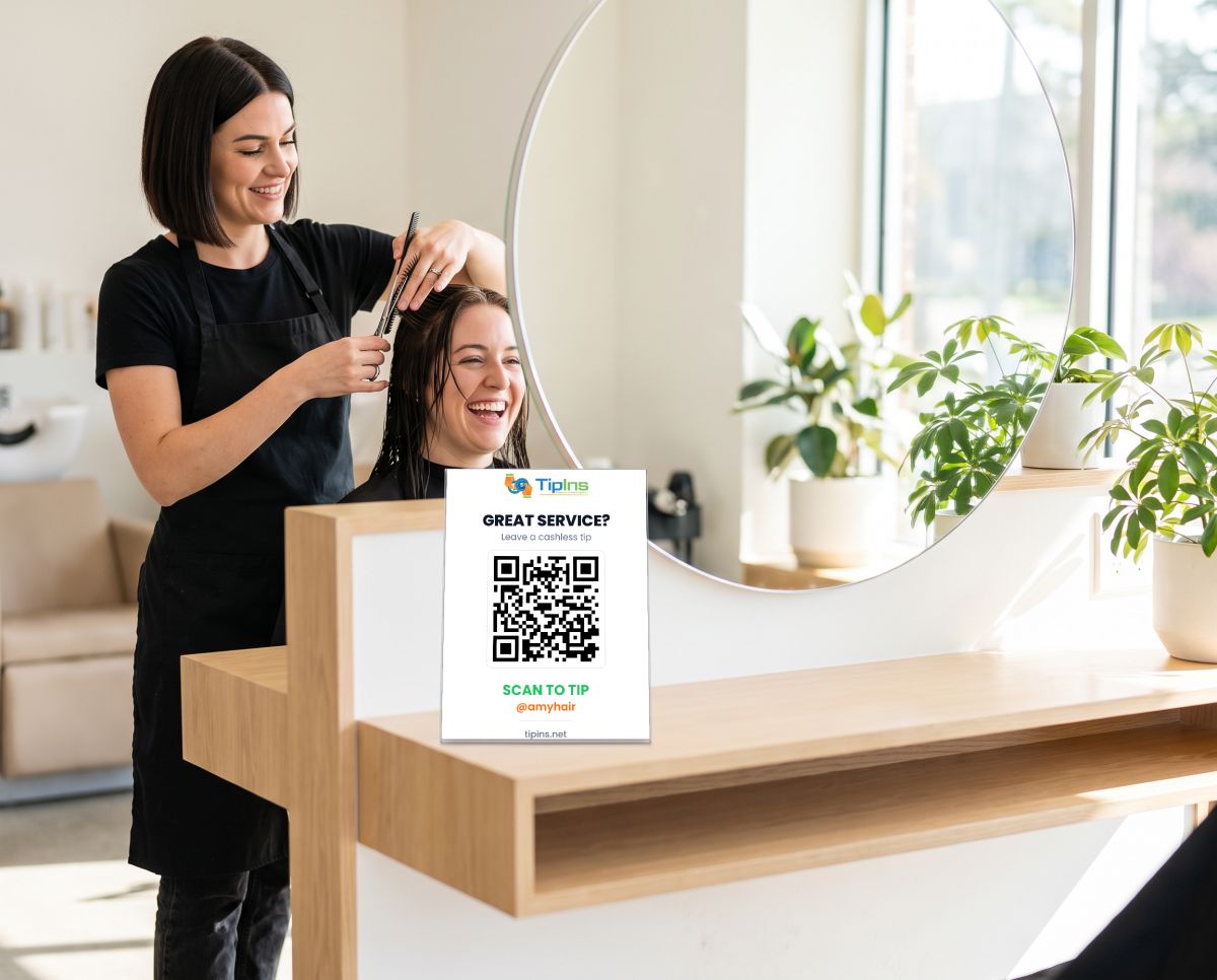Amy cutting a client's hair with a TipIns QR sign on the salon station