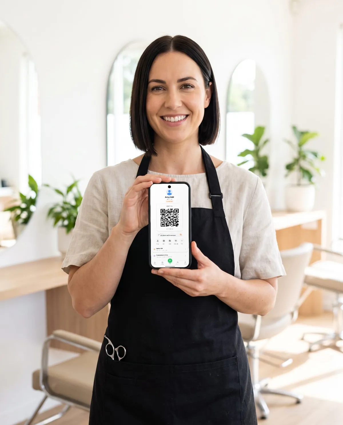 Una professionista del salone con in mano un telefono che mostra il suo QR code per le mance